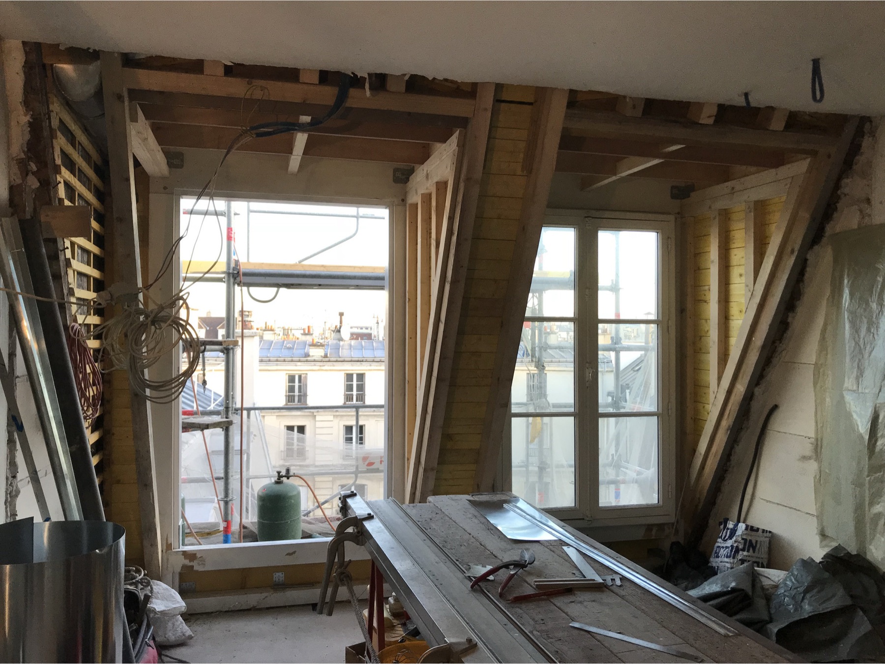 Lucarne en construction ouverte sur les toits.